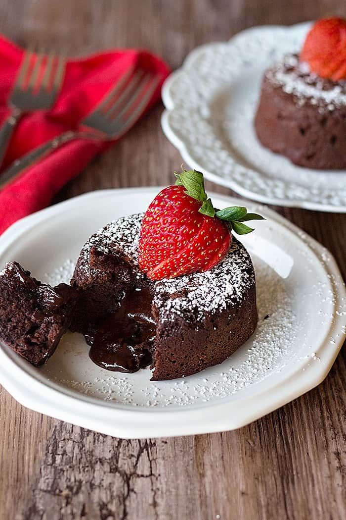 Molten chocolate cake topped with powdered sugar and a strawberry. 