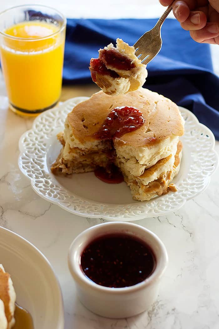 Peanut Butter and Jelly Stuffed Pancakes are two favorite breakfast foods in one! They are fluffy with a center of creamy peanut butter and jelly. It can't get any better! 