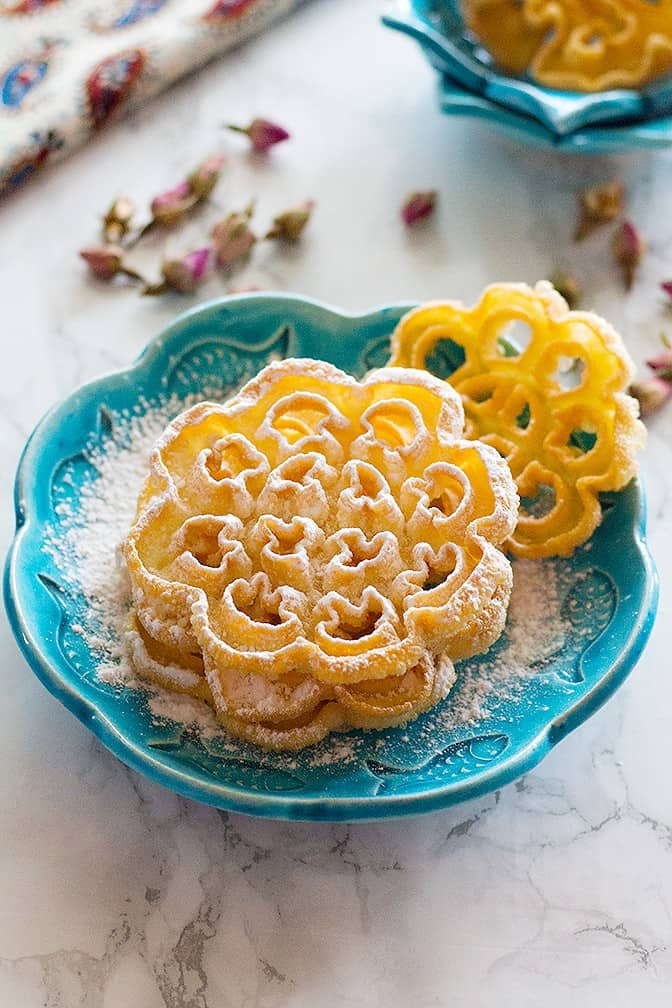 Nan Panjereh - Persian Rosettes is a traditional Persian cookie that is crisp and light. It's made of basic ingredients and once you find the technique, it is easy and fun to make!