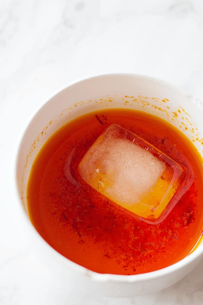 Sprinkle ground saffron on a couple cubes of ice and wait for it to melt. 