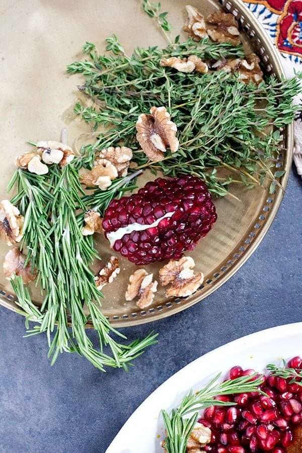 Use pomegranates and herbs to garnish the turkey. 