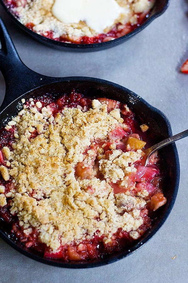 strawberry rhubarb crumble made in small cast iron skillets with a buttery crumble on top. 