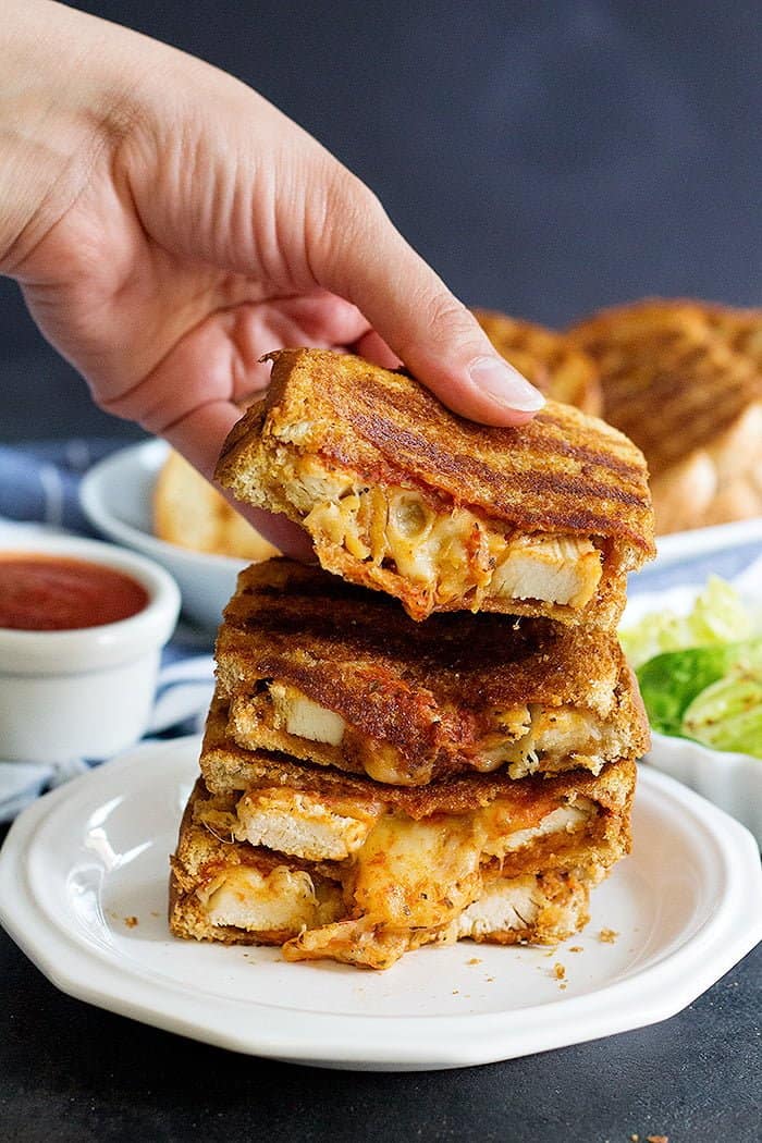 Grilled cheese chicken parmesan sandwich is the best of both worlds! Delicious chicken smothered in tomato sauce, pressed between two slices of bread with a lot of cheese!