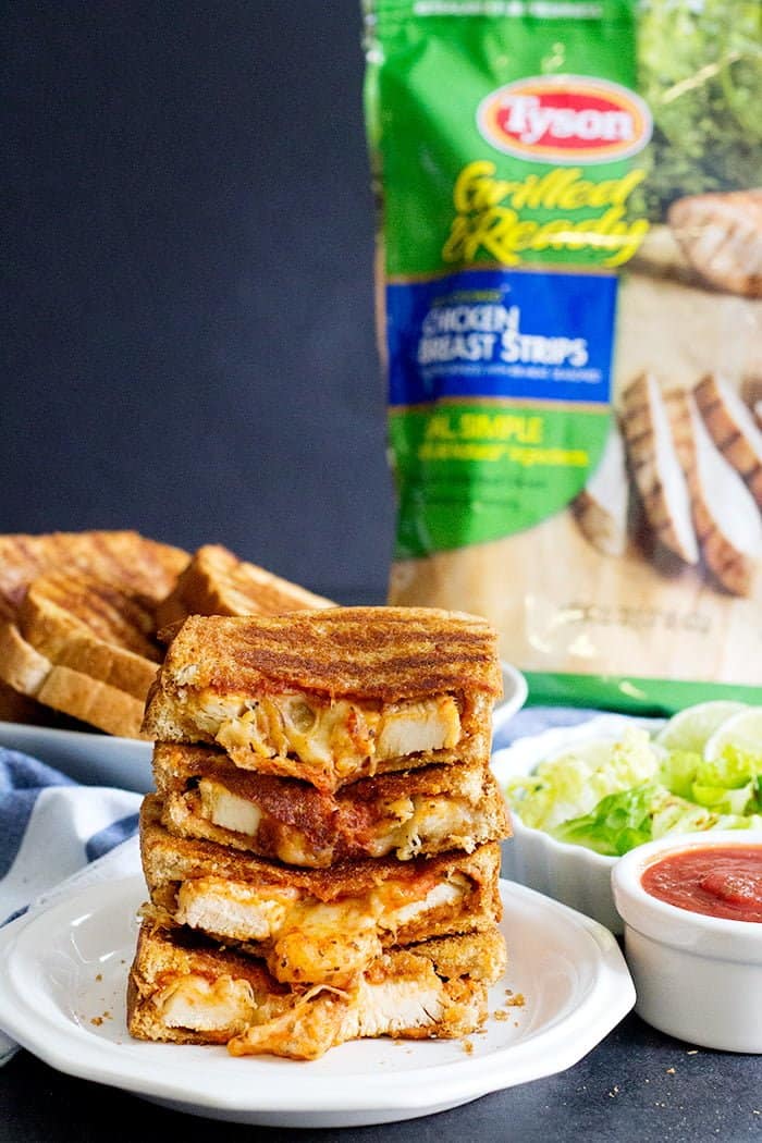 A stack of grilled cheese chicken parmesan sandwich with melted cheese. 