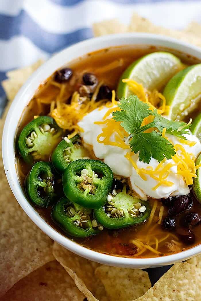 Chicken tortilla soup topped with sour cream, jalapeno and lime wedges.