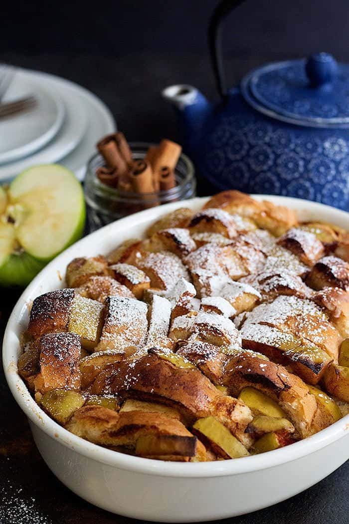 slices of baked bread with apples and cinnamon topped with powdered sugar. 