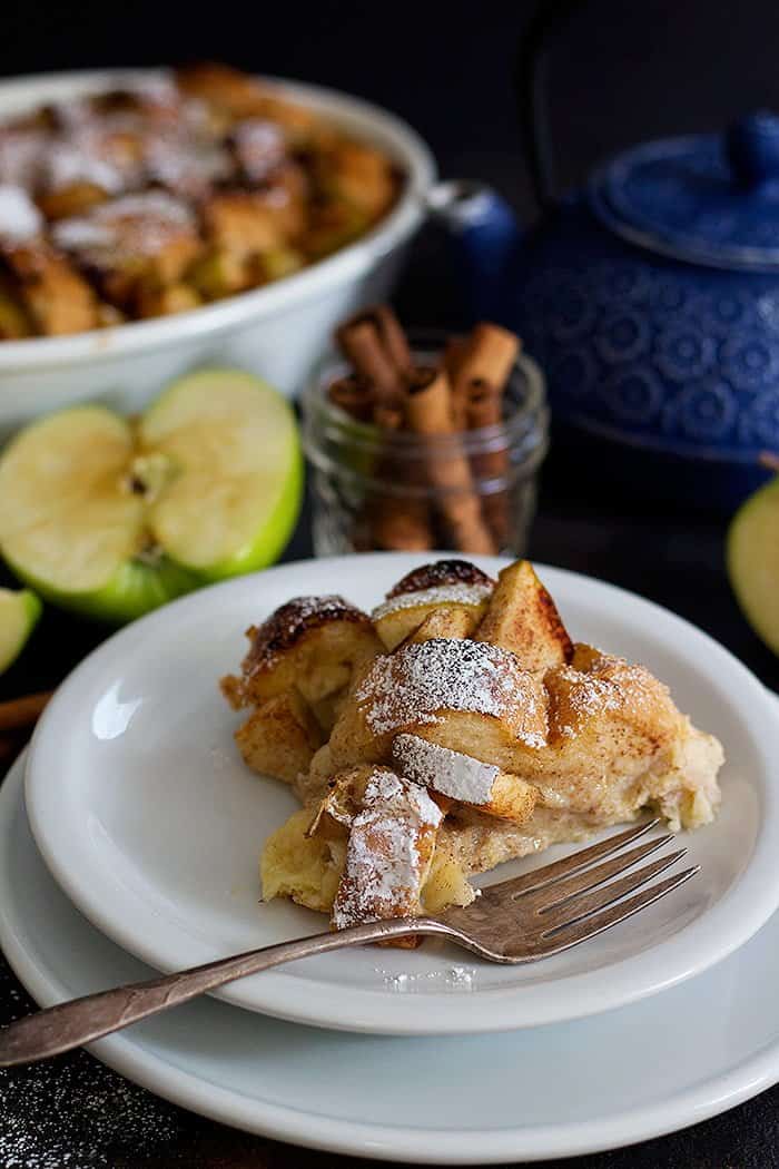 A slice of gooey apple Cinnamon breakfast bake on a white plate. 