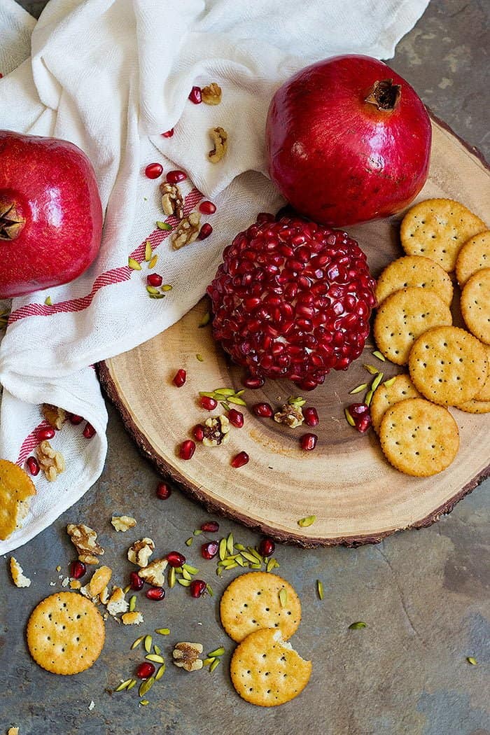 Pomegranate Cheese Ball with pomegranate arils, pistachios and crackers.