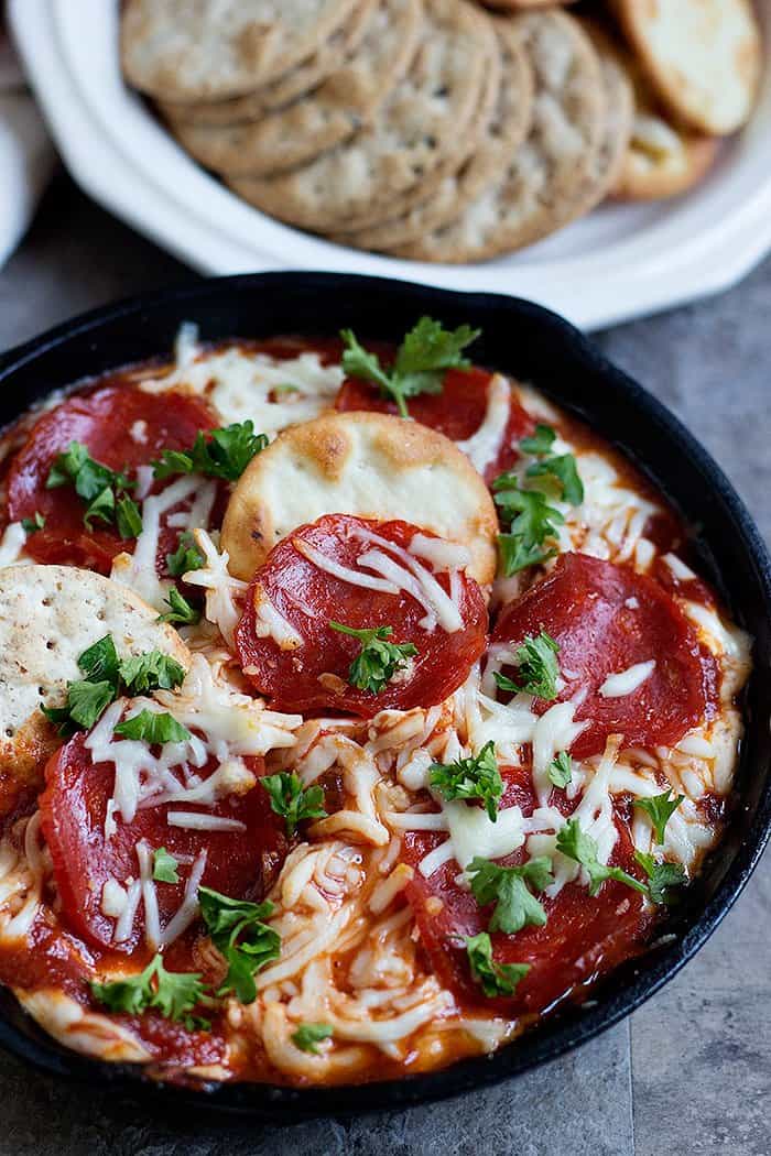 Pepperoni pizza dip topped with parsley and mozzarella cheese. 