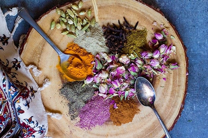 A wooden board with a variety of spices on it. 