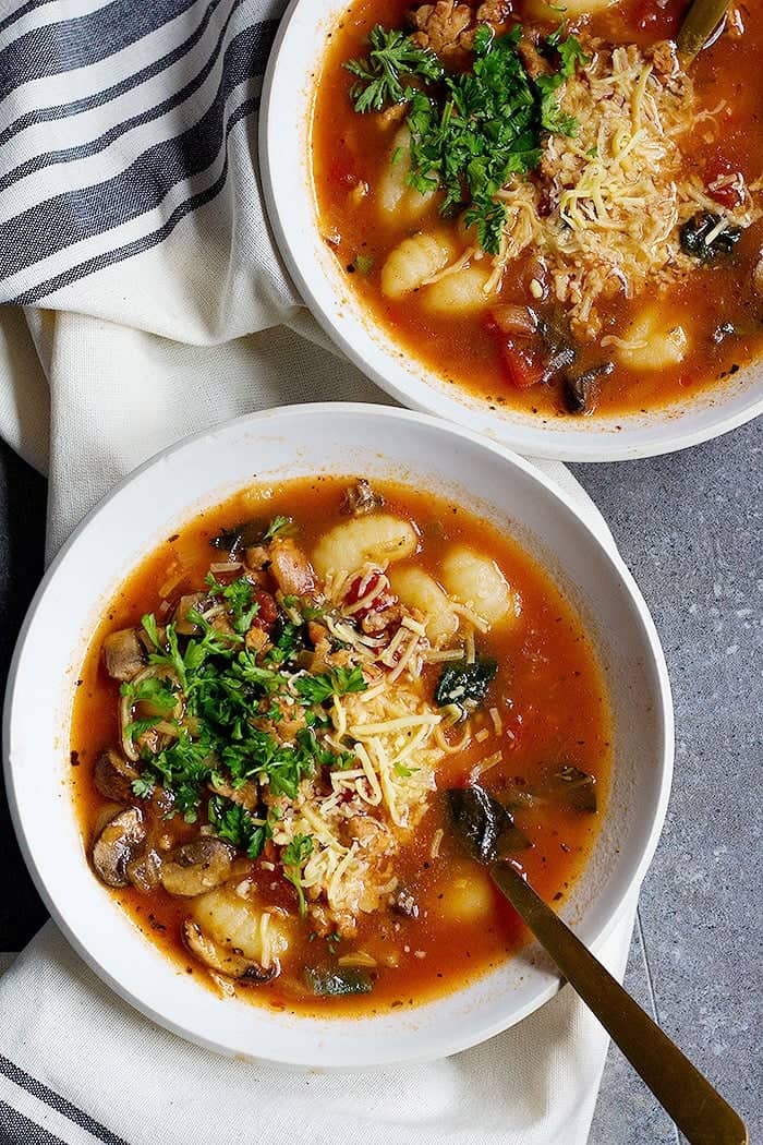 Bowls of Soup with gnocchi topped with Parmesan cheese. 
