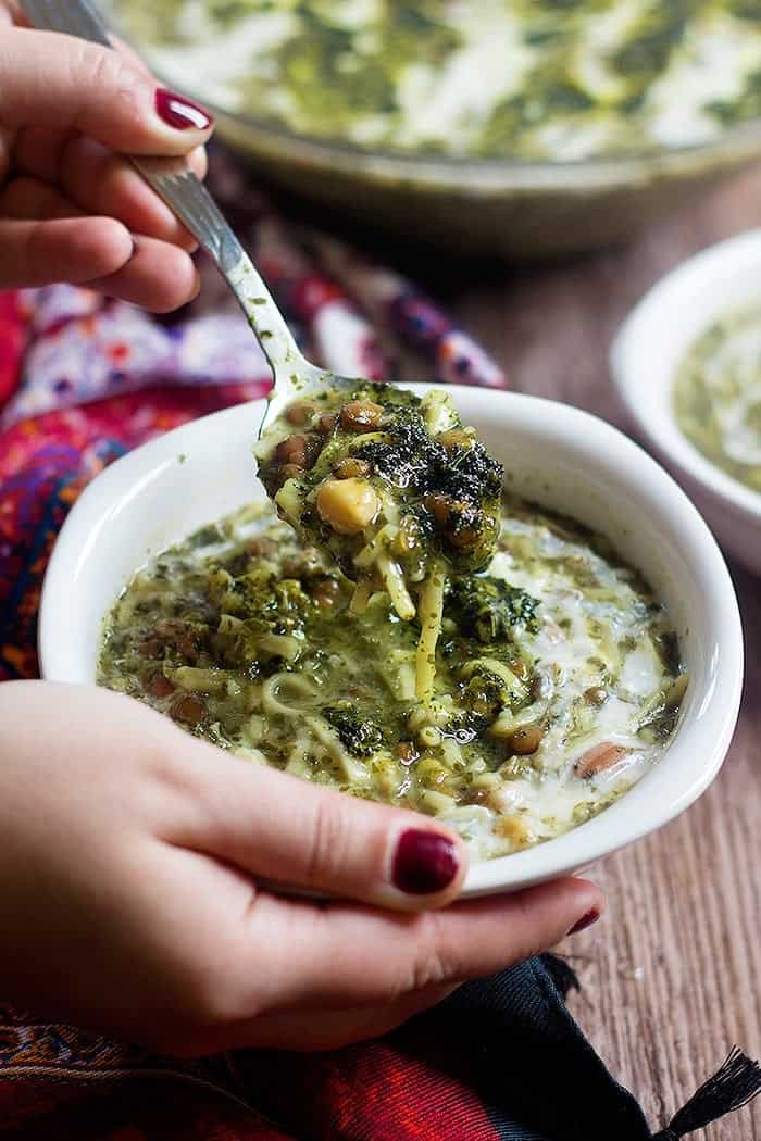 a bowl of Persian noodle soup and a spoon.