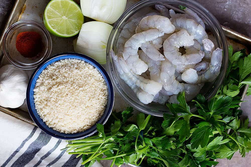 To make shrimp patties you need shrimps, onion, bread crumbs, spices, parsley, garlic and lime 
