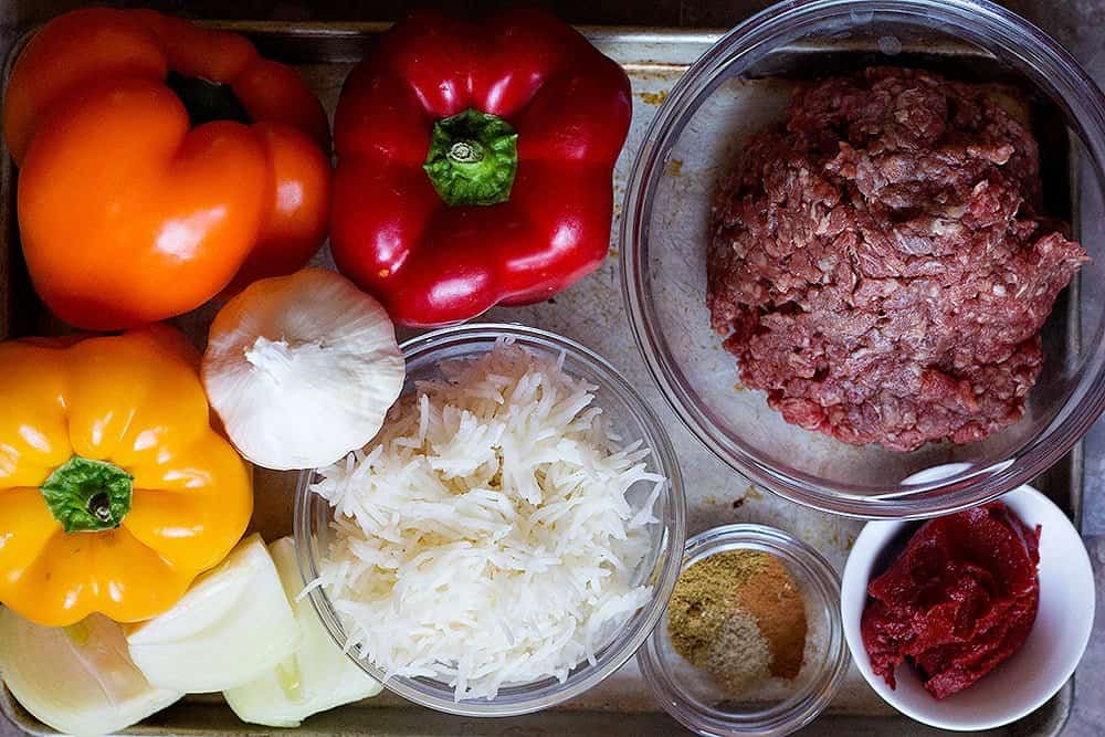 To make stuffed peppers in oven you need bell peppers, ground beef, onion, garlic, rice, tomato paste and spices. 