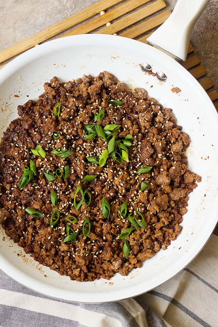 Top ground beef with sesame seeds and scallions.