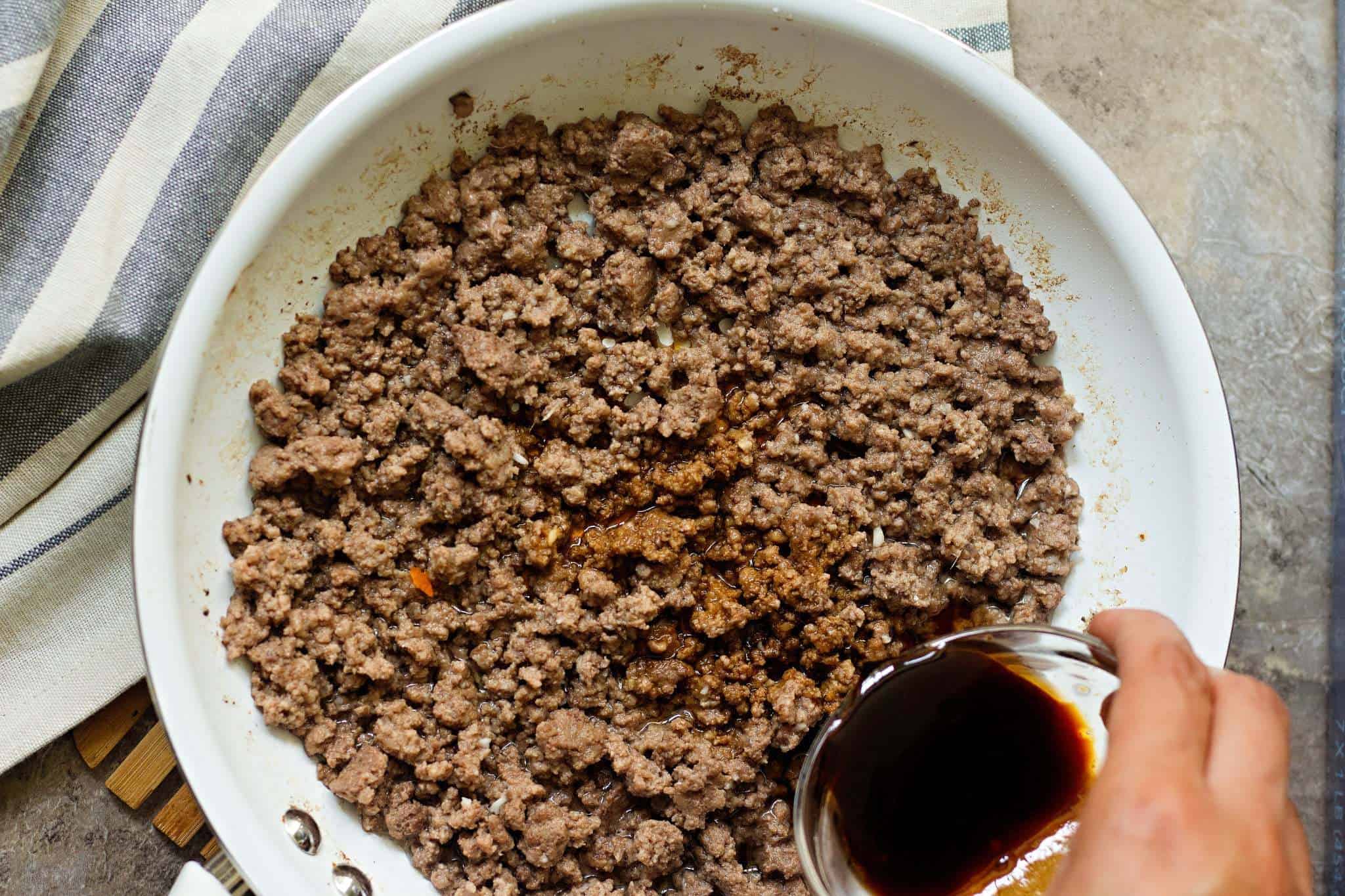 To make Korean beef and rice, saute ground beef until brown and then add brown sugar and soy sauce.