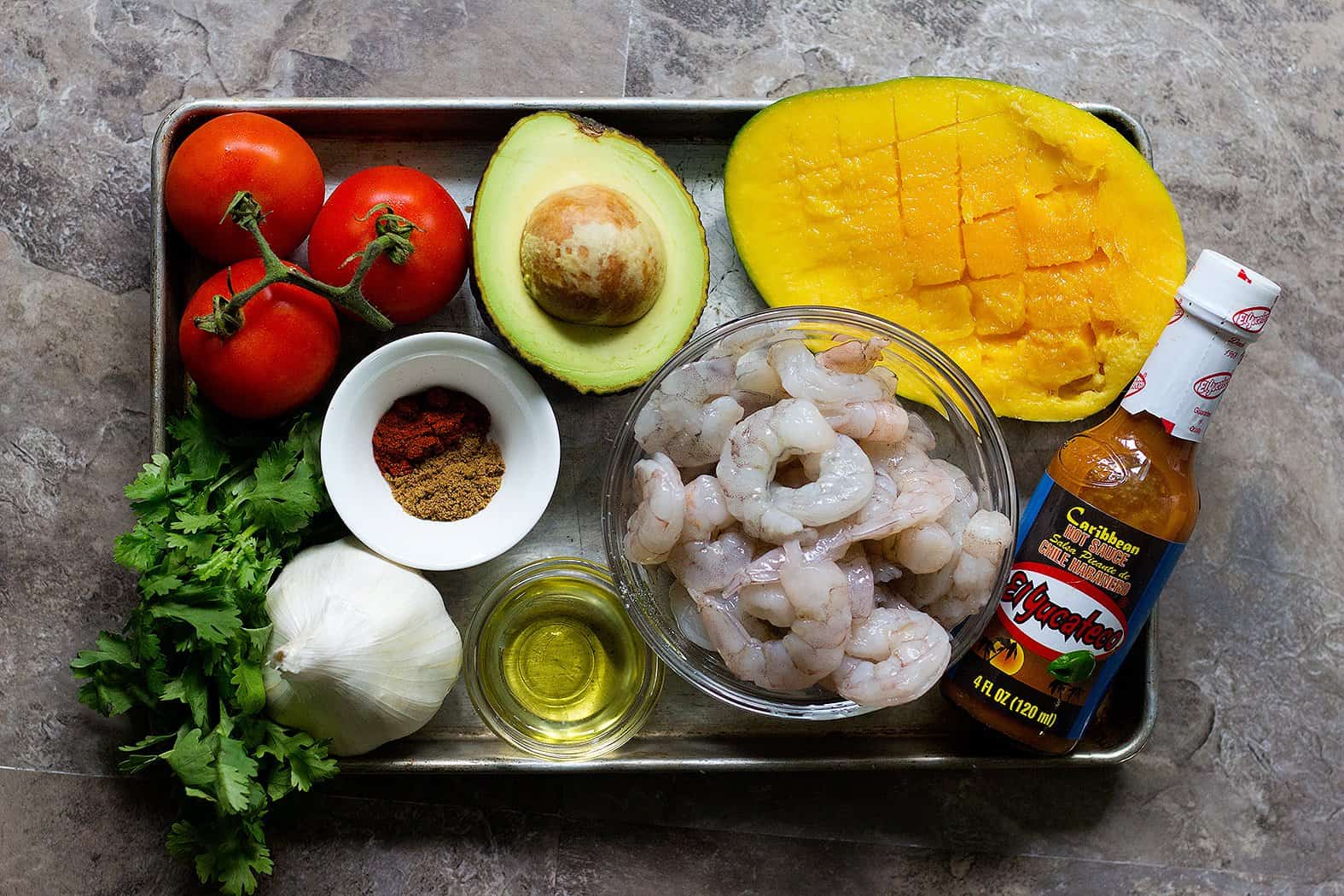 For spicy shrimp tacos you need shrimps, hot sauce, mango, olive oil, spices, garlic and avocado