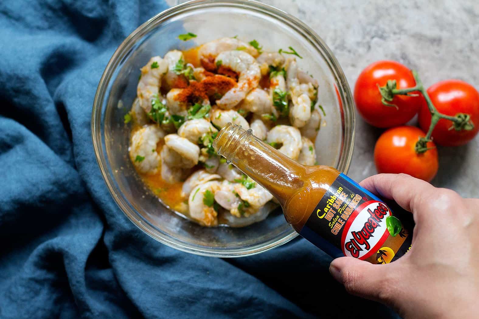 For spicy shrimp tacos marinade, add hot sauce to the shrimps. 