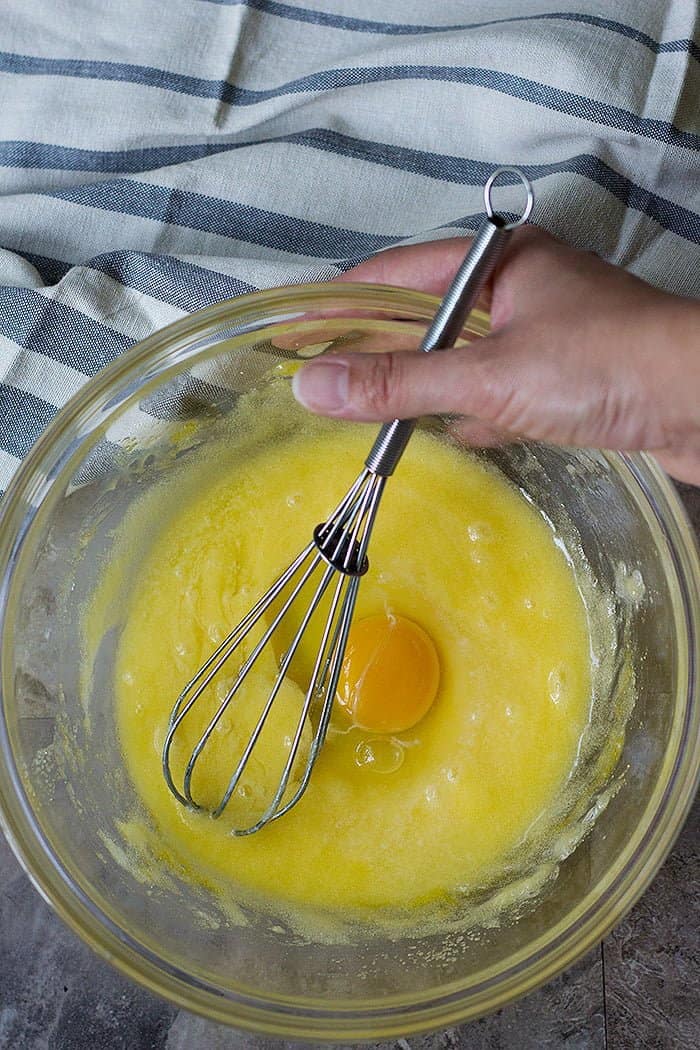 mixing melted butter and sugar in a large bowl