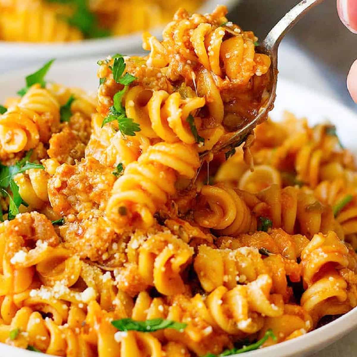 pasta and sausage topped with parmesan cheese. 