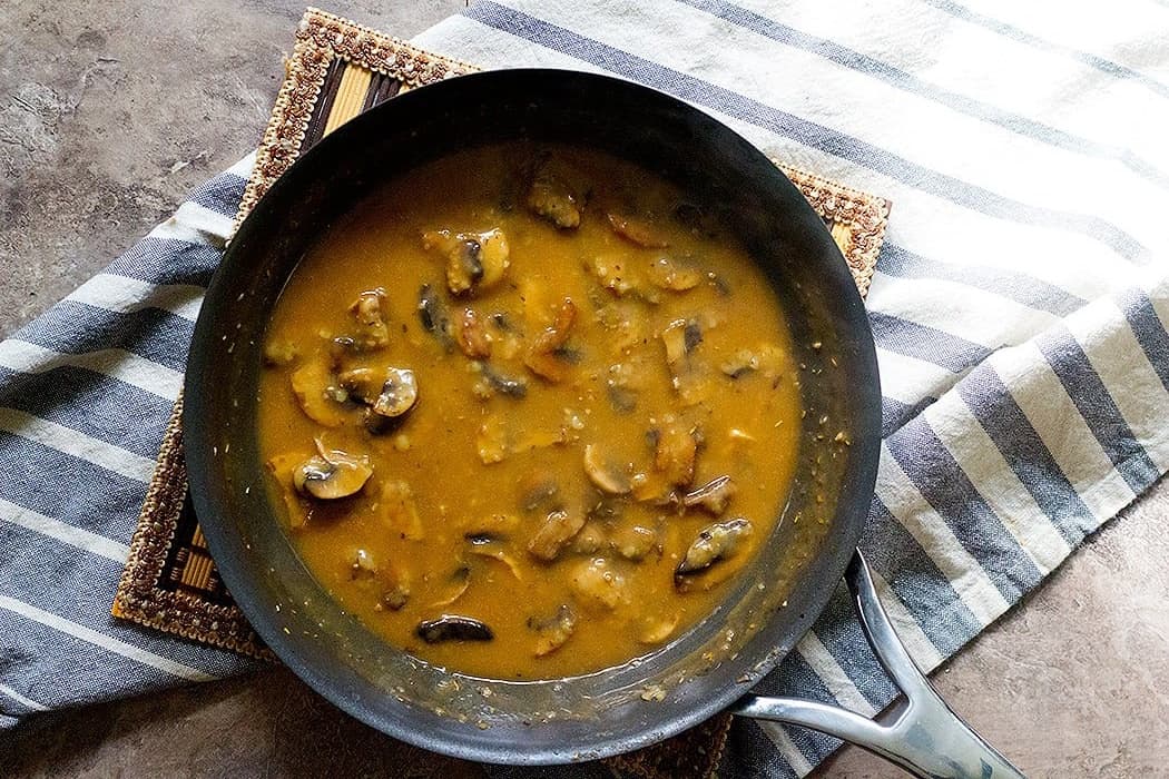 Add chicken stock and cook the mushroom gravy until it thickens. 