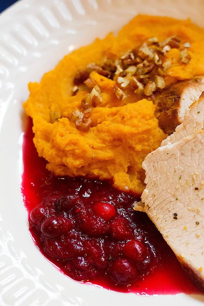 A Thanksgiving dish with sweet potatoes, cranberry sauce and turkey. 