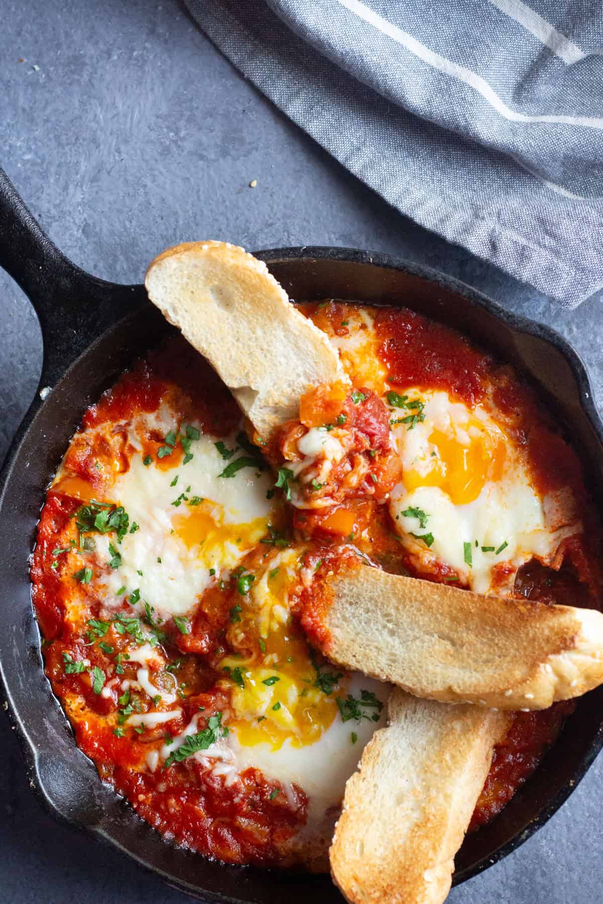 Serve Italian baked eggs with crispy bread.