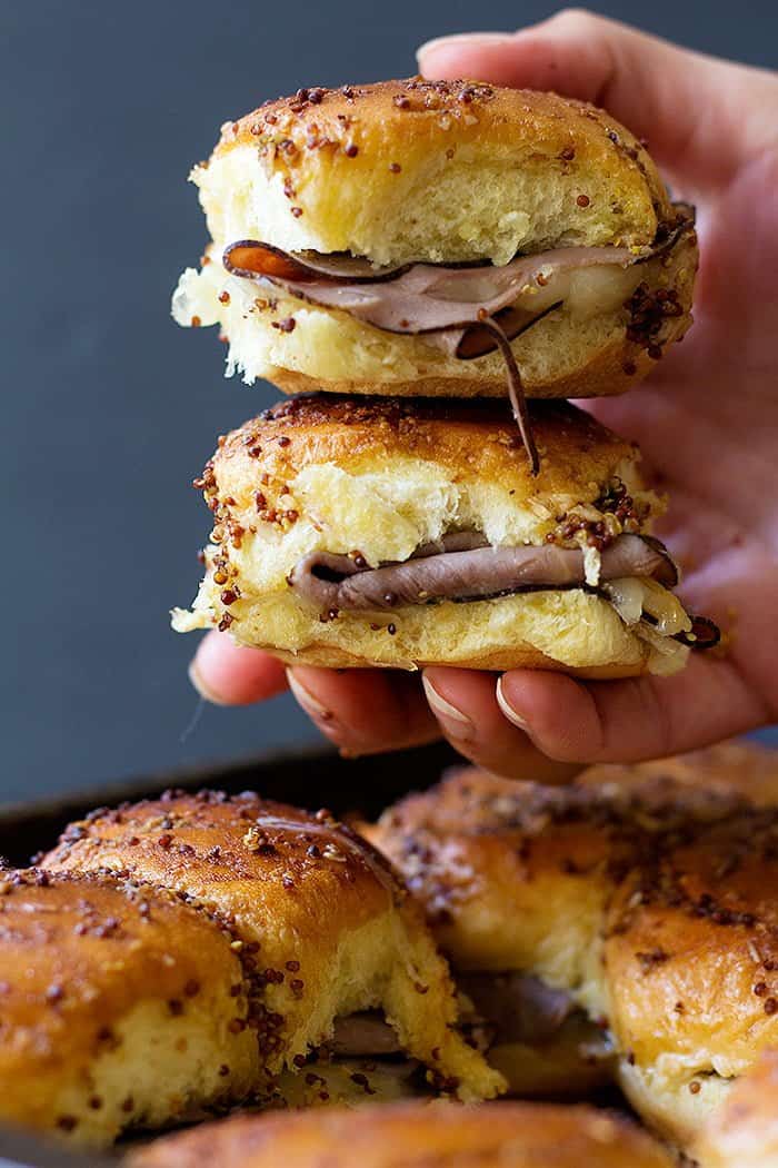Roast beef sliders are the perfect game day food! Layers of roast beef and cheese between Hawaiian rolls are topped with the most delicious spread and cooked to perfection. 