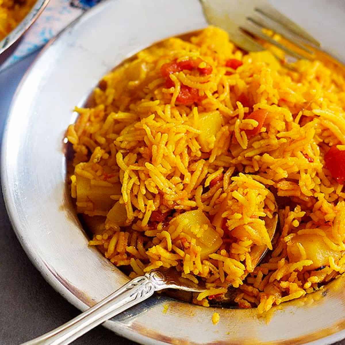 Persian tomato rice on a plate with a spoon. 
