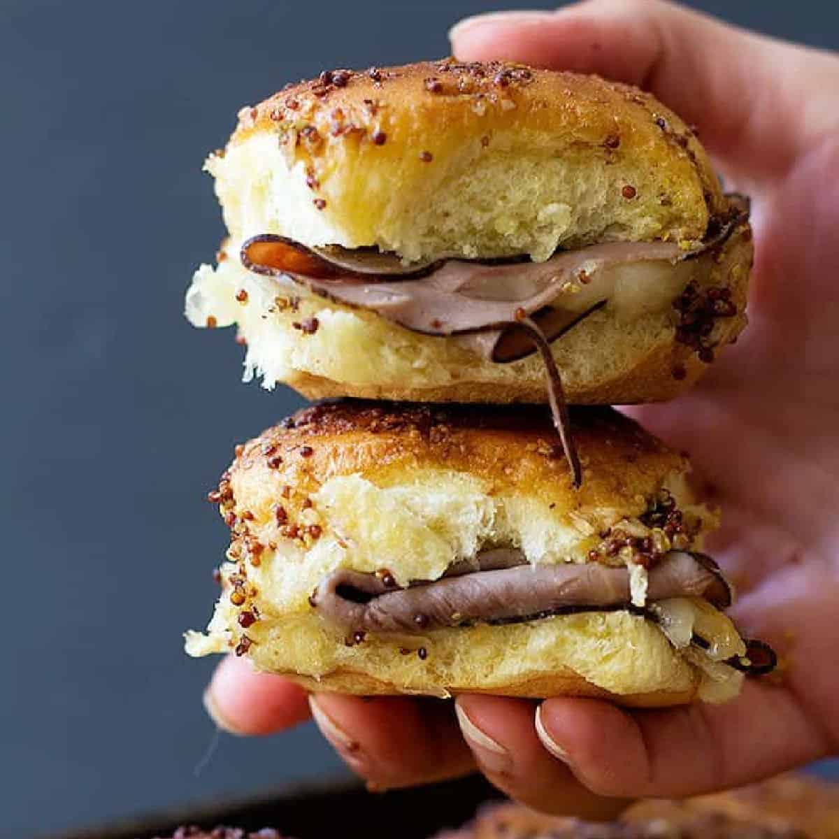 Roast beef sliders are the perfect game day food! Layers of roast beef and cheese between Hawaiian rolls are topped with the most delicious spread and cooked to perfection. 
