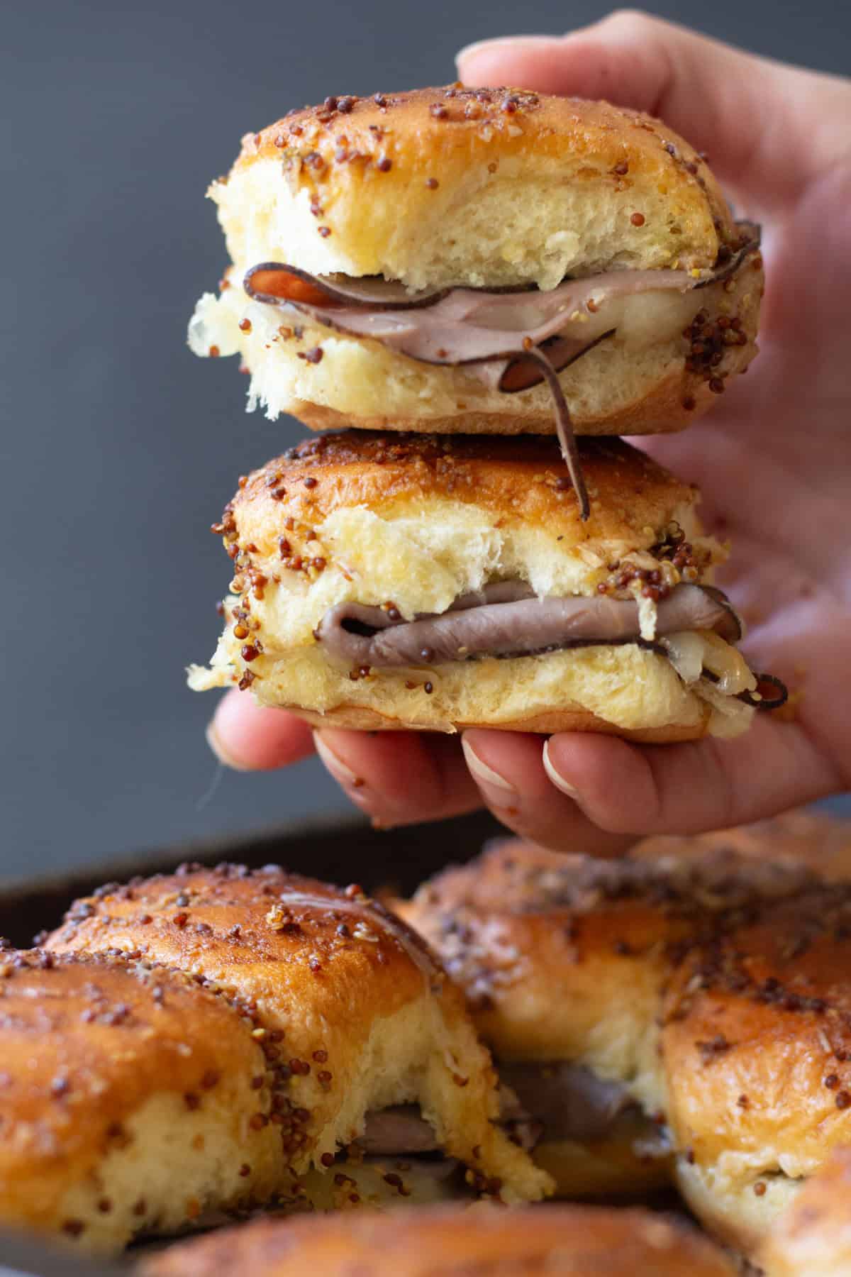 Roast beef sliders are the perfect game day food! Layers of roast beef and cheese between Hawaiian rolls are topped with the most delicious spread and cooked to perfection.&nbsp;