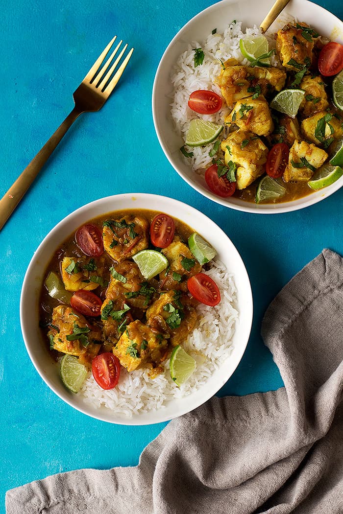 a delicious fish curry is served with some white rice. 