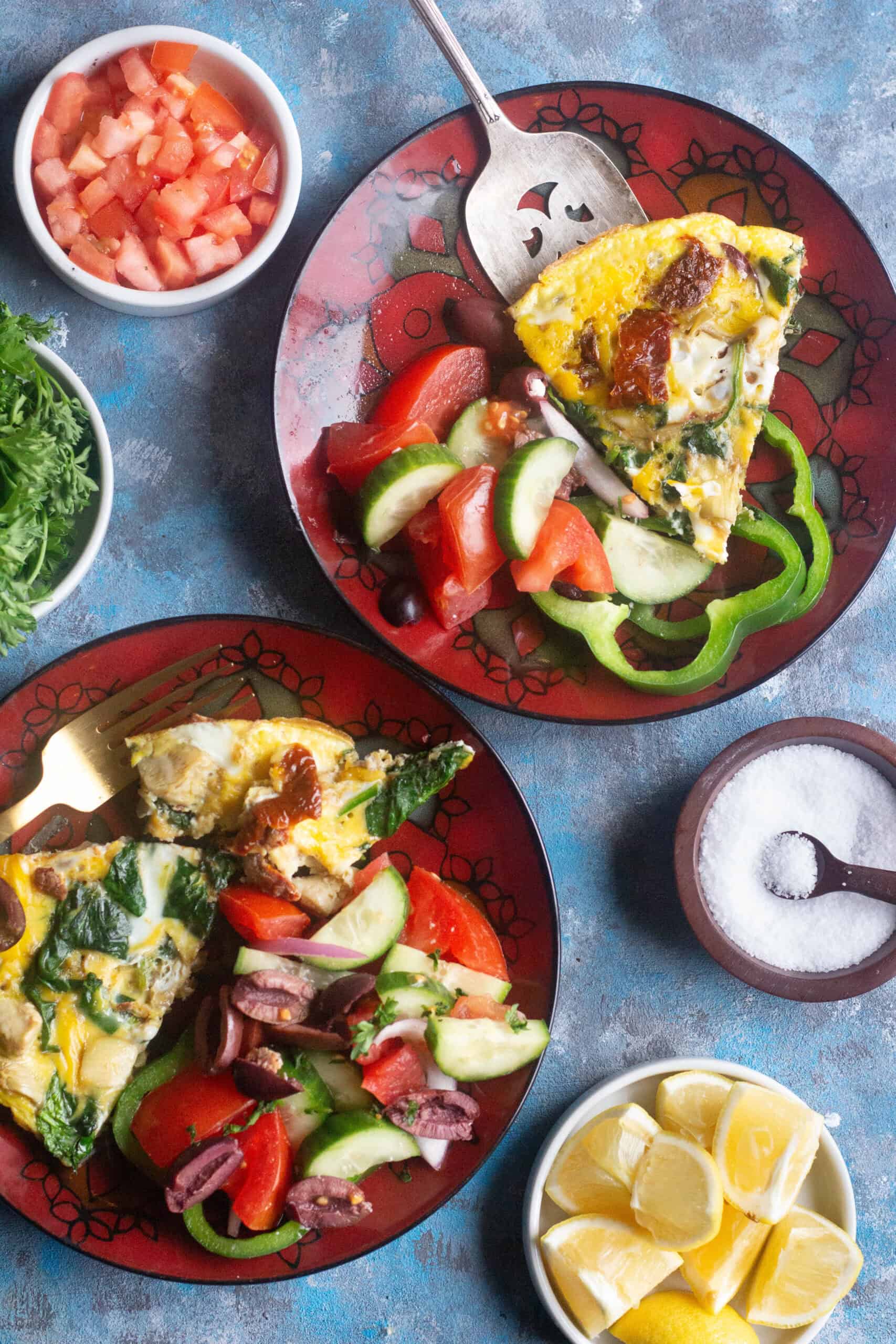 Overhead shot of spinach omelette on plates with salad.