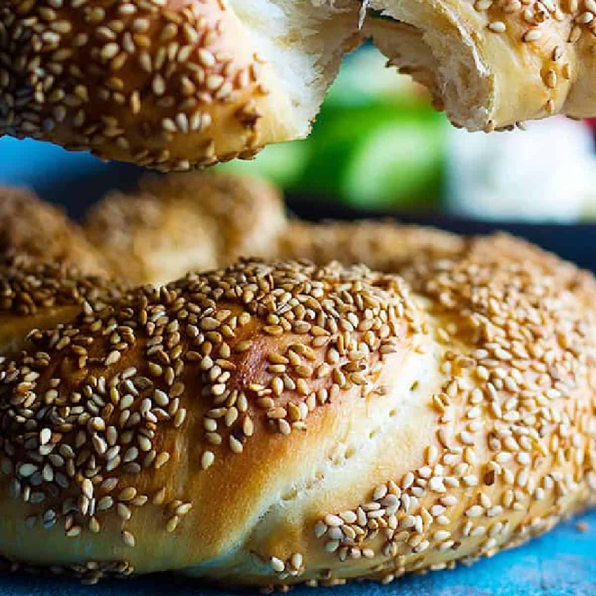 Turkish simit is a delicious sesame crusted bread that you can have for breakfast. Learn how to make traditional simit recipe at home with this step-by-step tutorial. 
