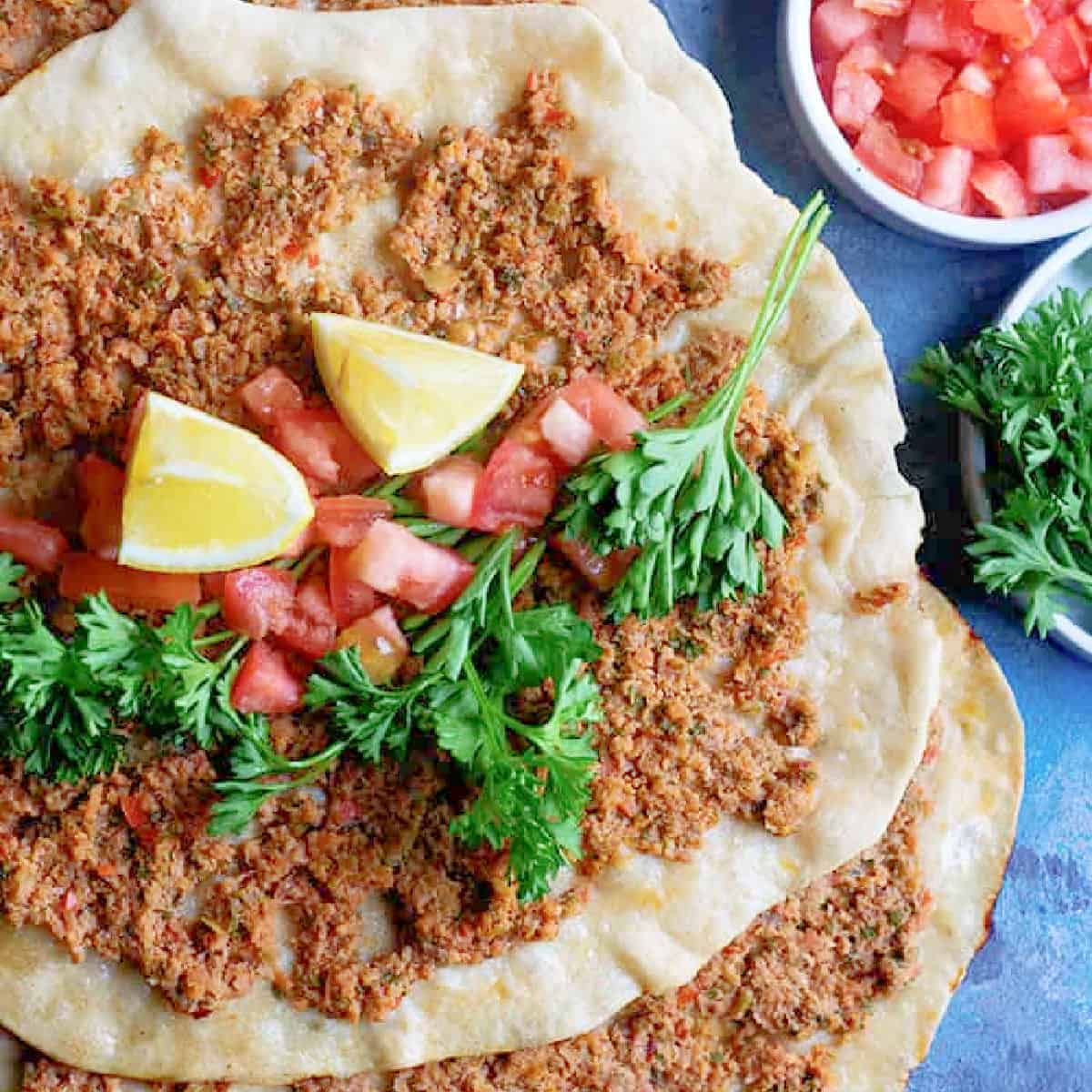 Lahmacun is thin and crispy flatbread bursting with flavor. Topped with meat, parsley, peppers, tomatoes and a mixture of delicious spices, this Turkish pizza is a must-try! 
