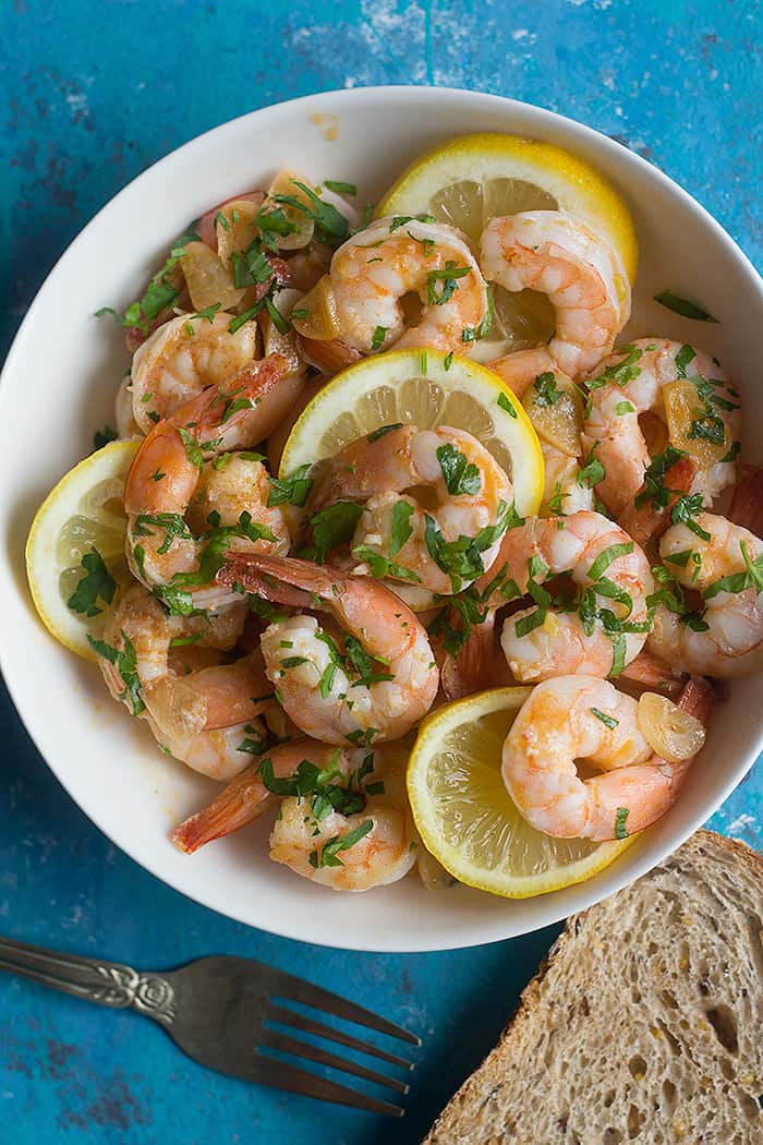lemon shrimp made with garlic olive oil and served in a bowl. Topped with chopped parsley. 