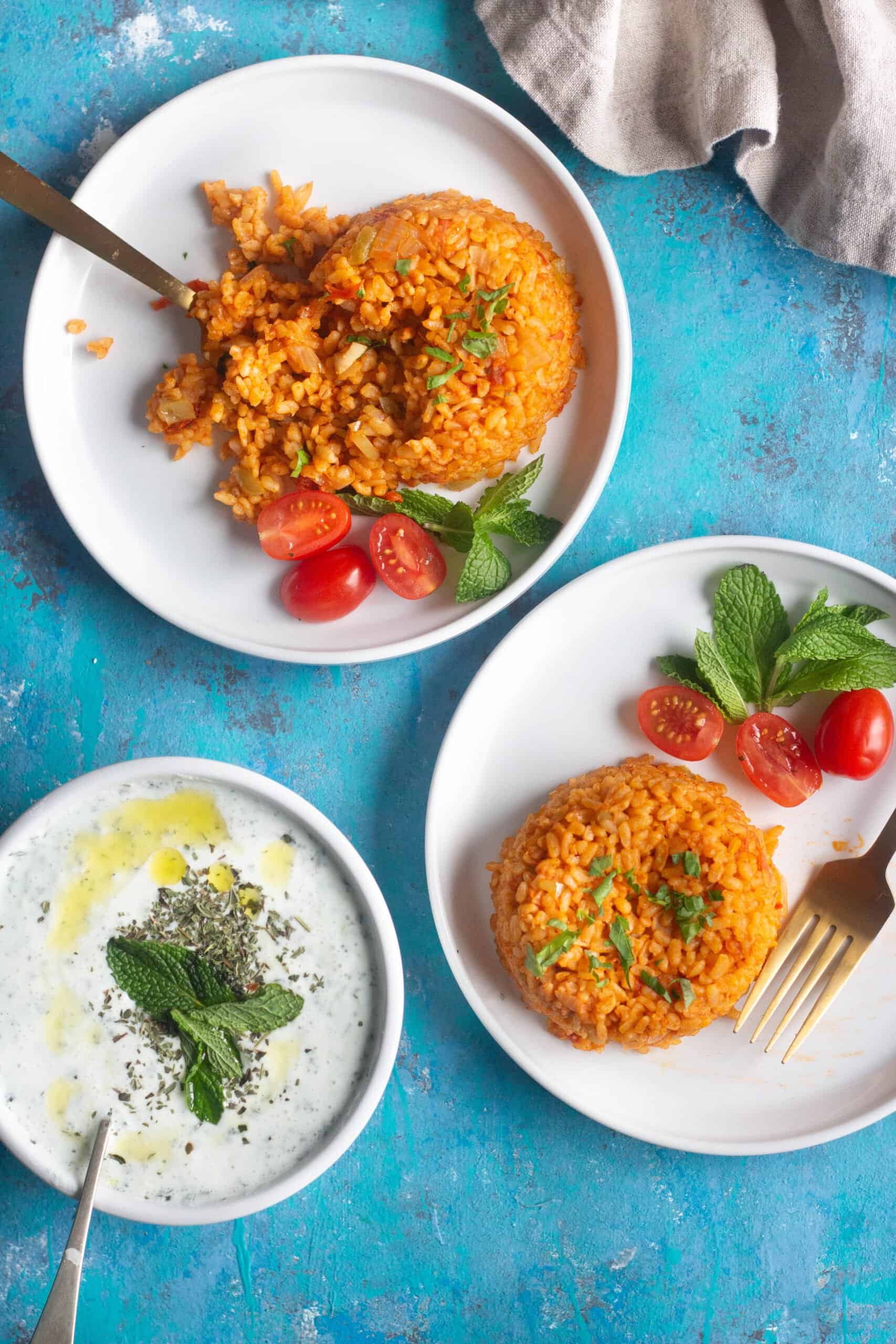 Two plates of food with yogurt and cucumber.