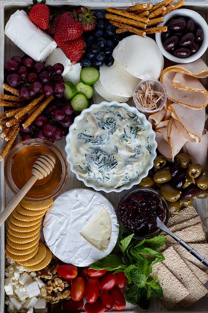 charcuterie board with cold spinach artichoke dip