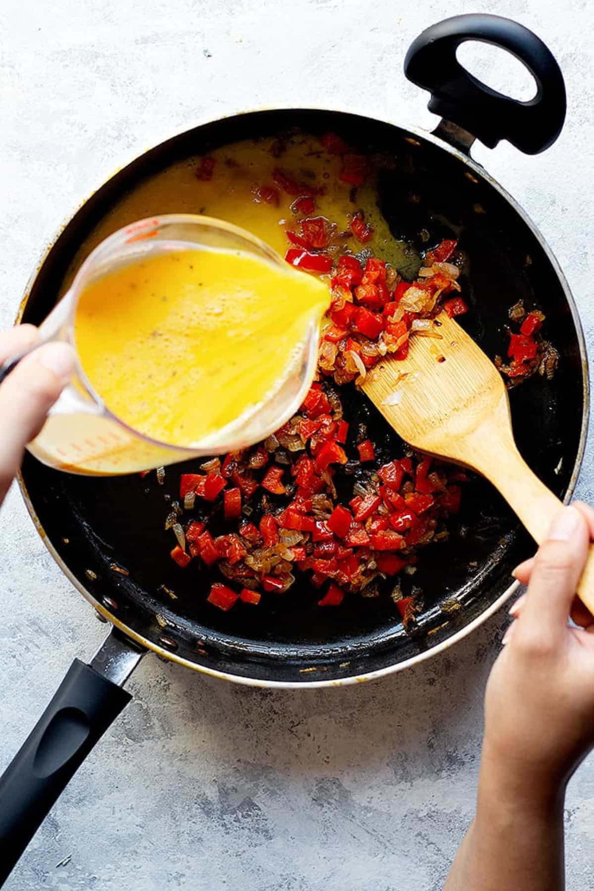 pour eggs into onion and peppers.