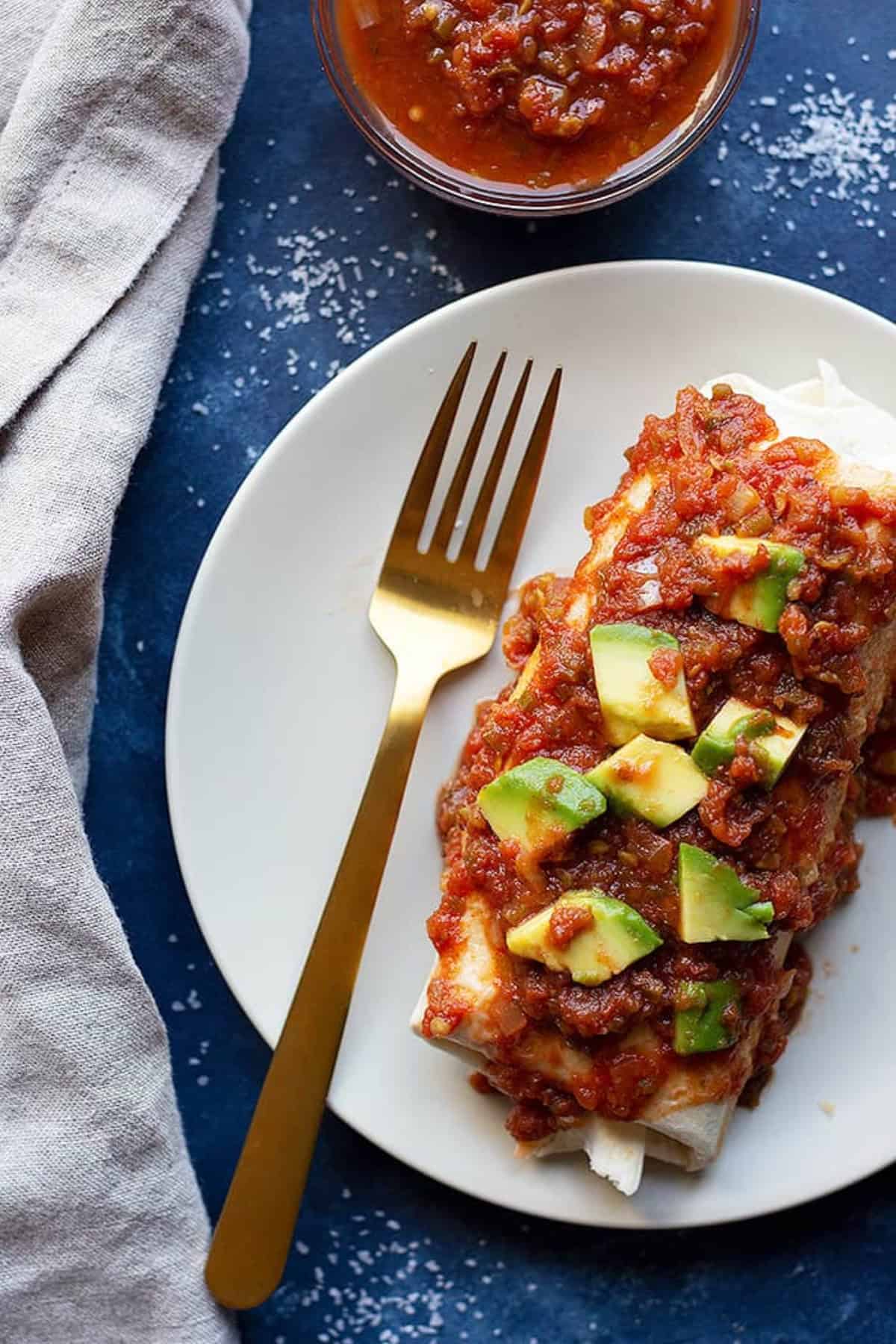 top the vegetarian breakfast burrito with warm salsa and avocados and serve.