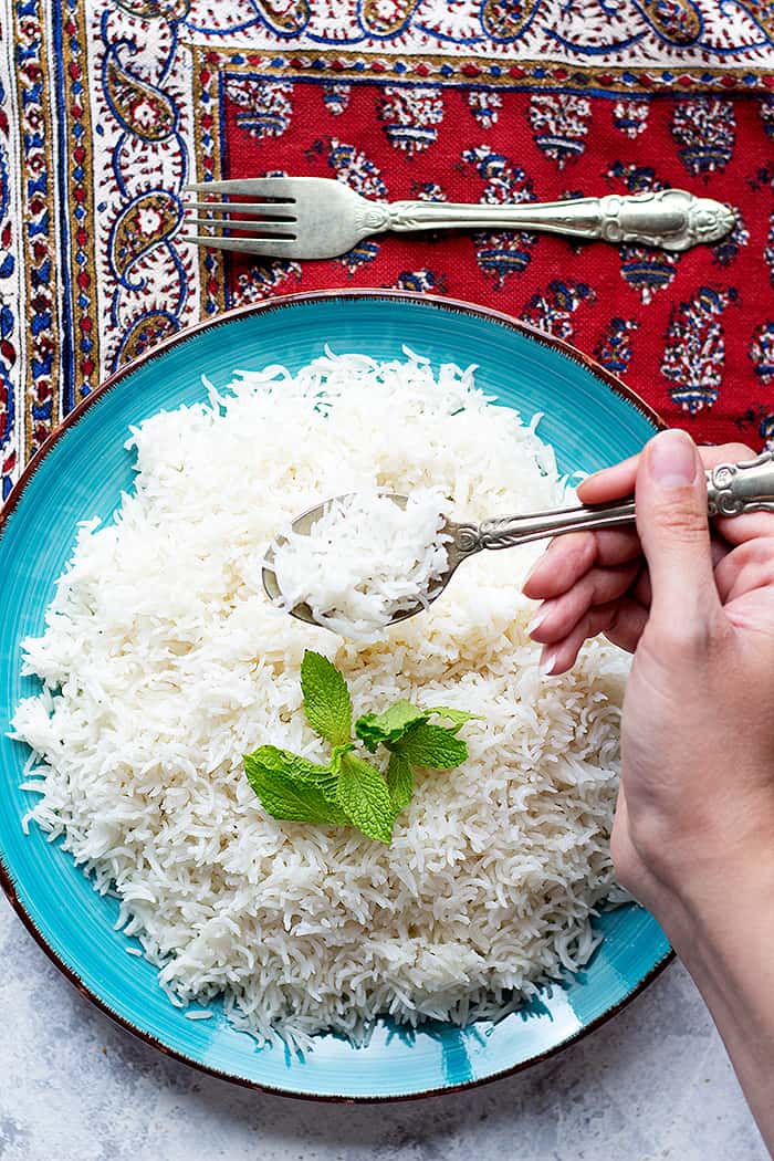 a blue plate full of rice topped with fresh mint. 