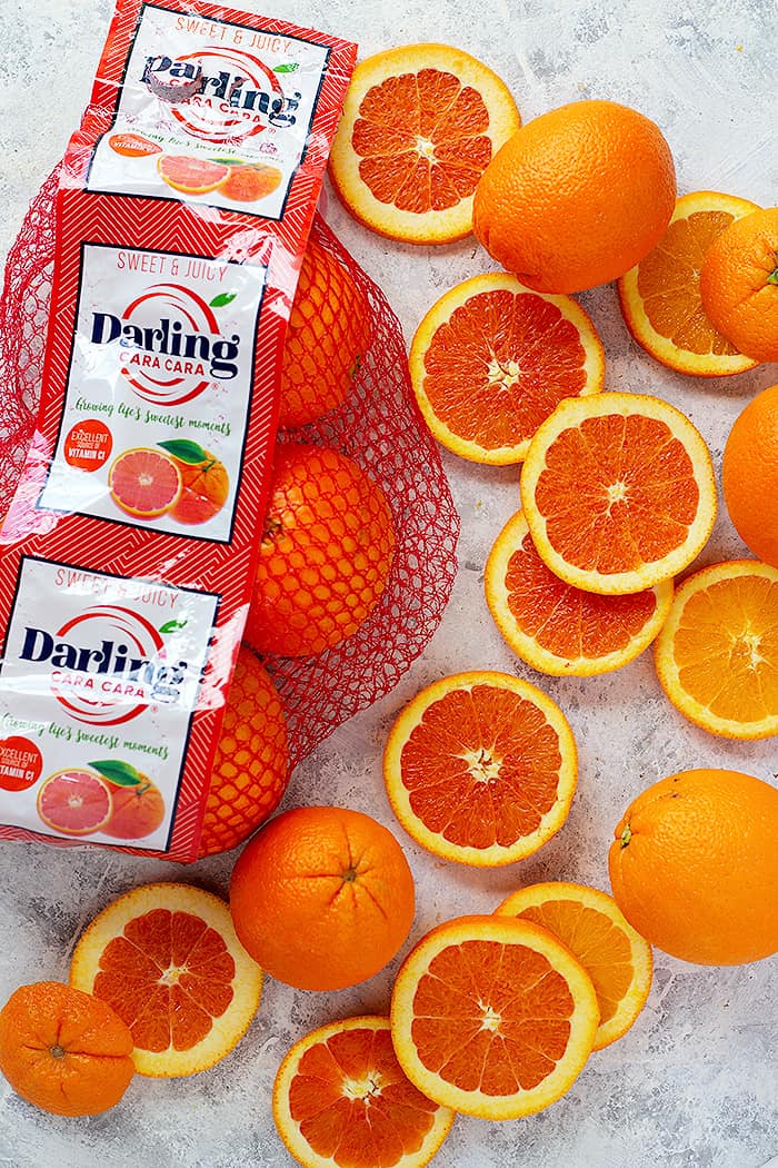 cara cara oranges sliced next to the packaging.
