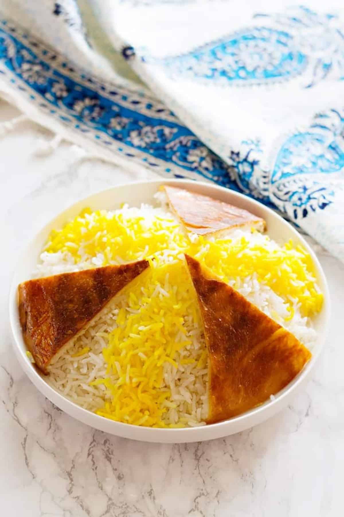 Persian Rice is the key element of Persian cuisine. Learn the easiest method with details once and make perfect Persian rice with a crispy golden crust called Tahdig every time.
