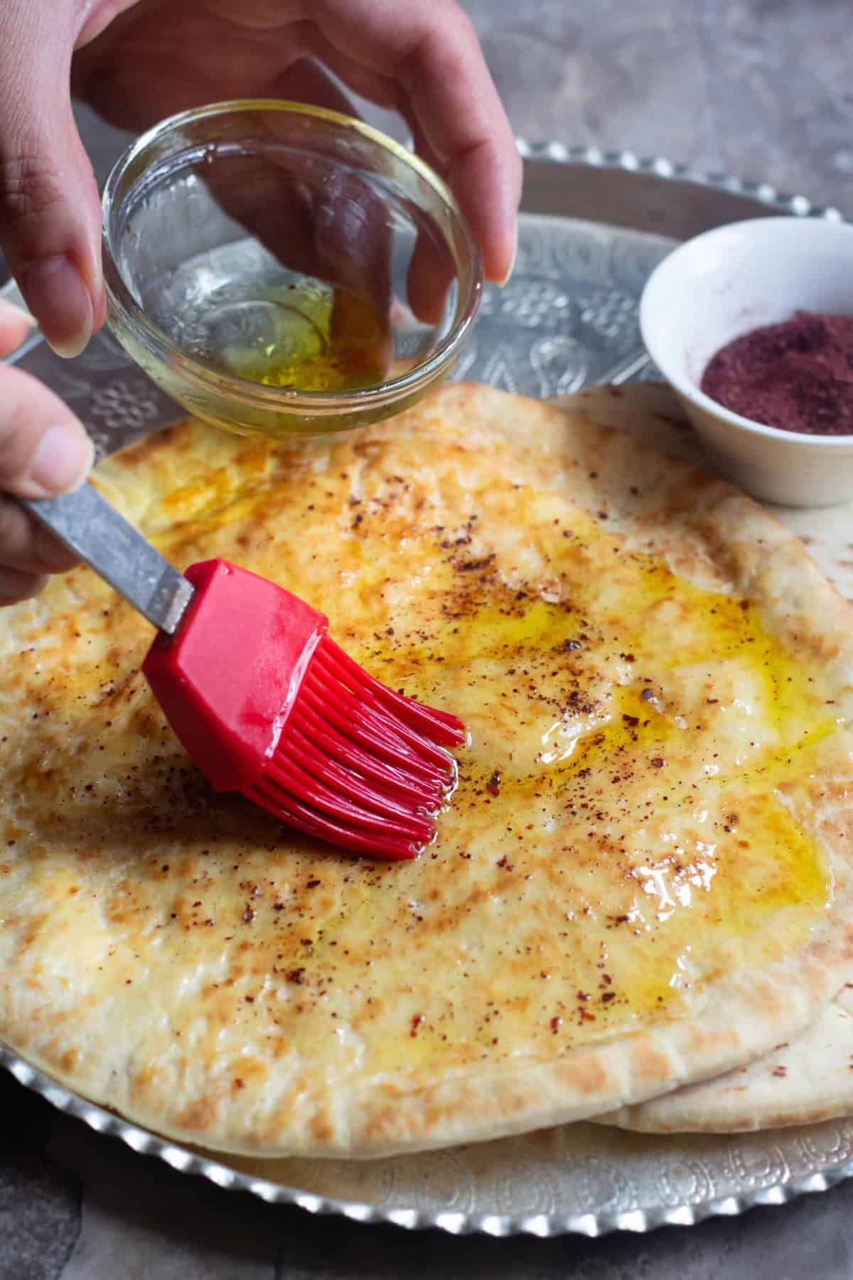 Brush the pita with olive oil and top with salt and sumac. 
