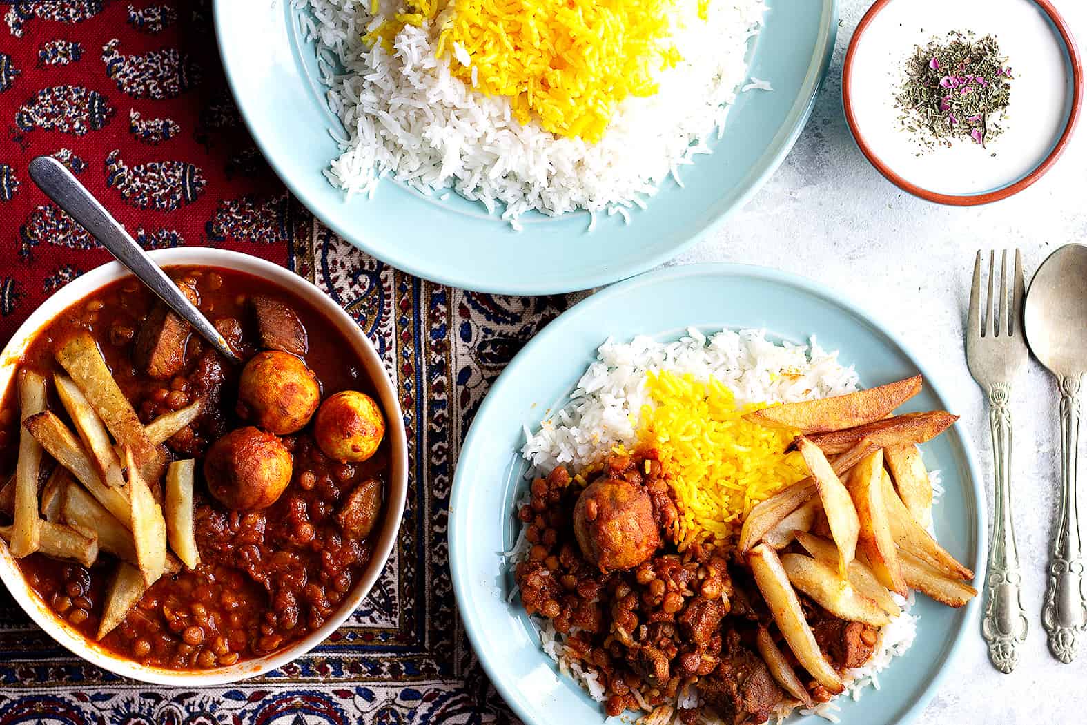 twp plates of rice serve with Persian gheimeh stew.