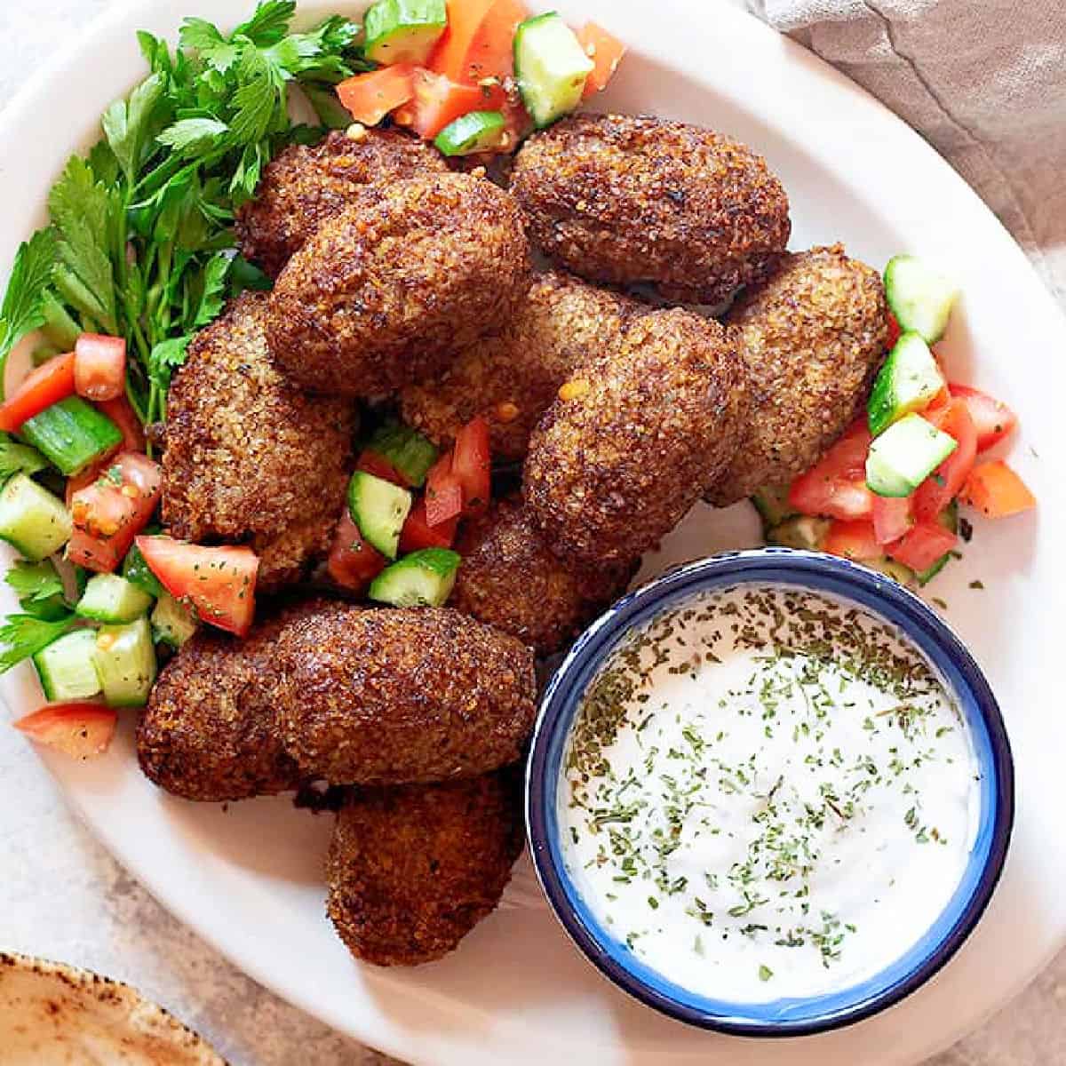 Kibbeh on a platter with salad. 