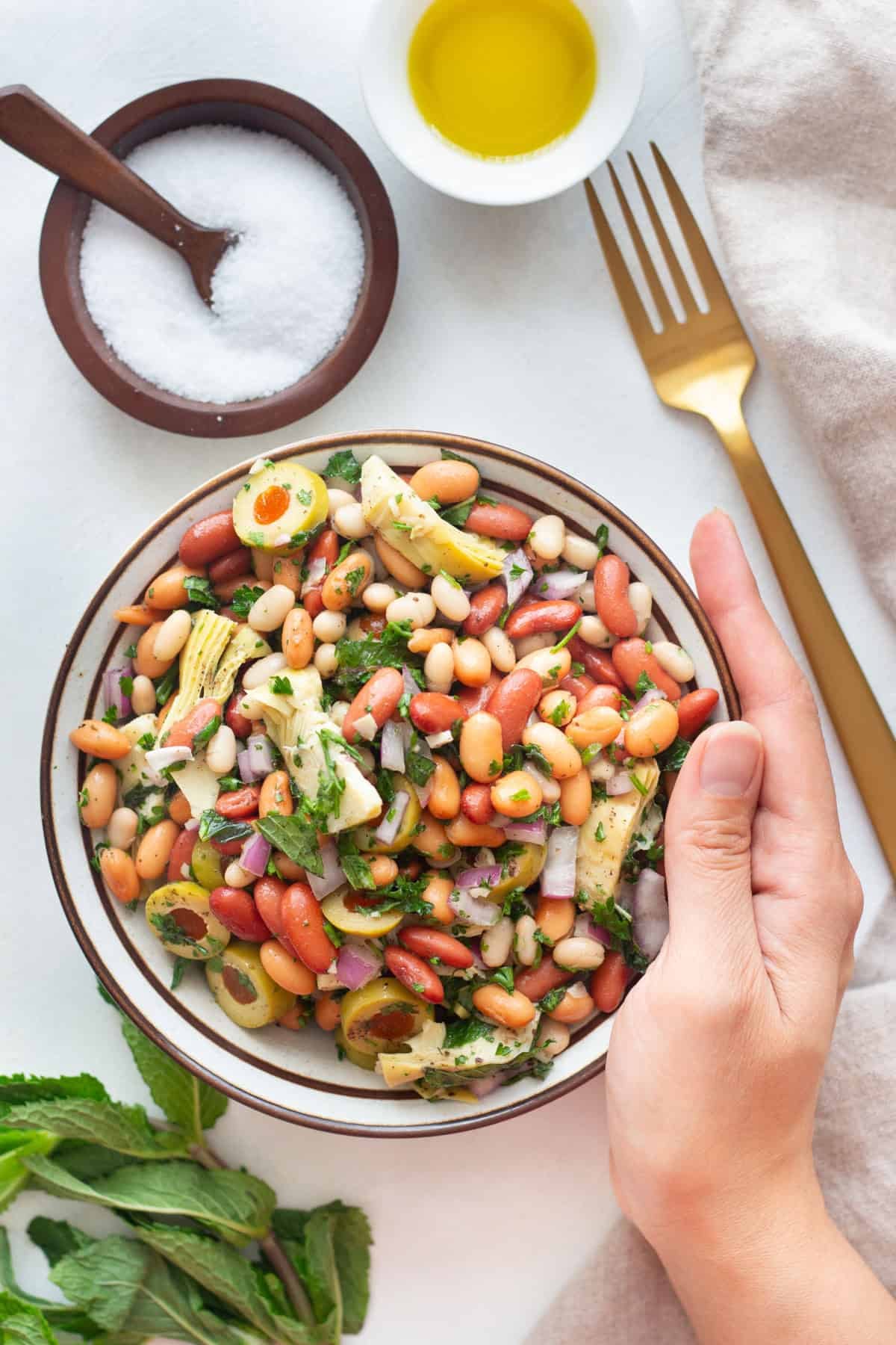 Two bowls of Mediterranean bean salad with mint and olive oil.