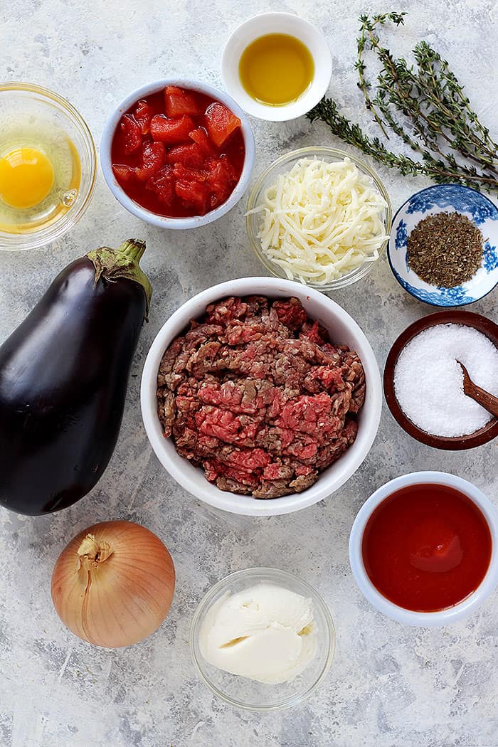 To make this recipe we need eggplant, onion, ground beef, tomatoes, egg, cheese, olive oil and spices. 