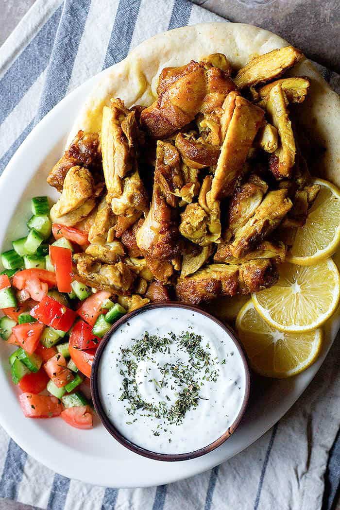 chicken shawarma is a delicious Mediterranean recipe that's served with pita, tomatoes, cucumbers and yogurt. 