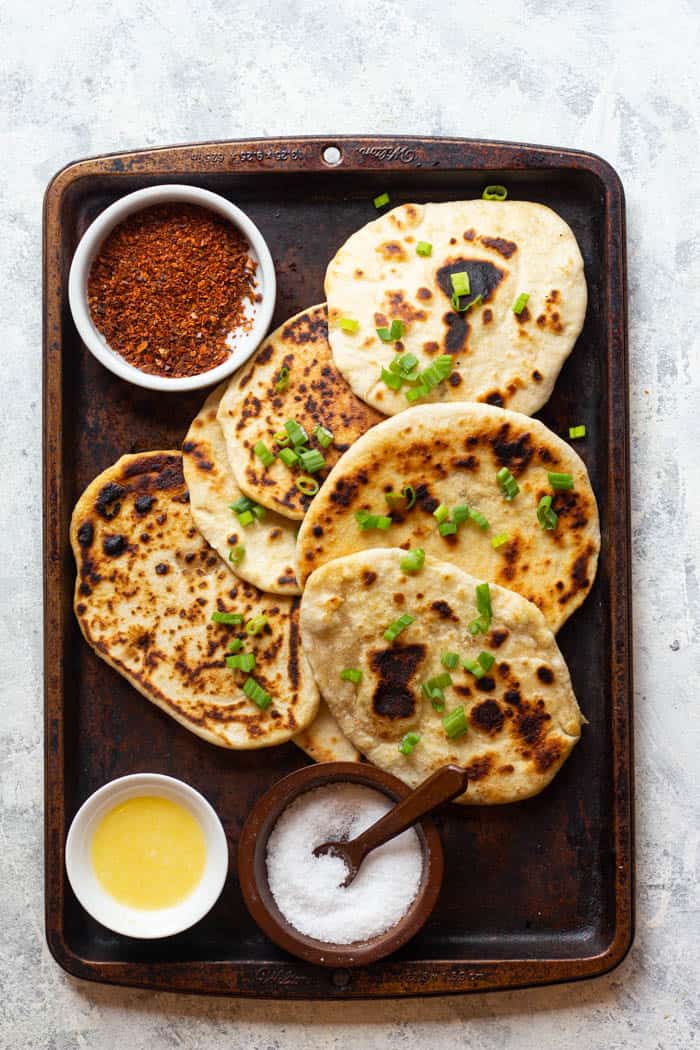 naan is brushed with ghee and topped with green onion.